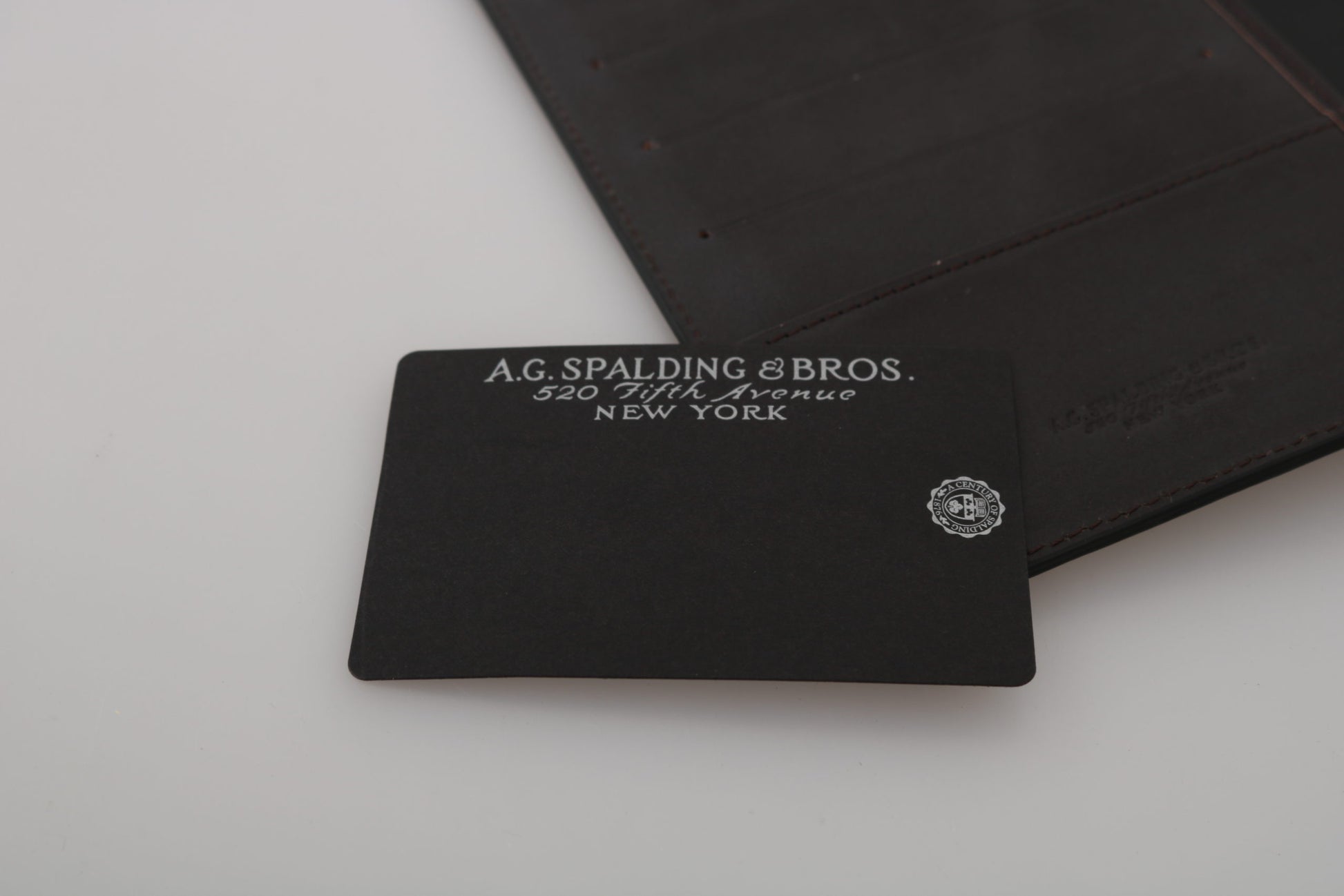 AG Spalding &amp; Bros. Schwarzes Leder-Reiseportemonnaie mit zweifacher Faltschließe und Logo